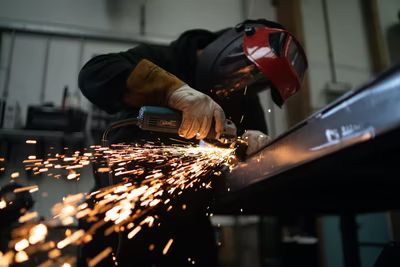 Worker Cutting Through Metal