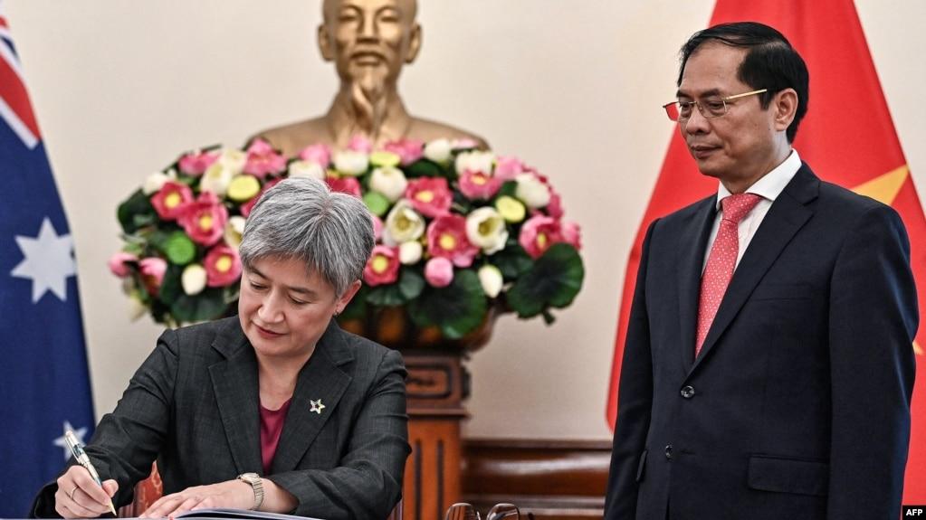 Ngoại trưởng Australia Penny Wong (trái) ký sổ lưu bút bên cạnh người đồng cấp Việt Nam Bùi Thanh Sơn tại trụ sở Bộ Ngoại giao ở Hà Nội ngày 22/8/2023. Bà Wong nói Úc sẽ nâng cấp quan hệ với Việt Nam.