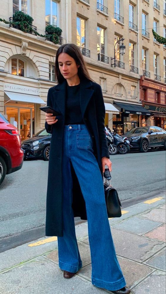 a lady pairing her high-waist flare jeans with a black blazer