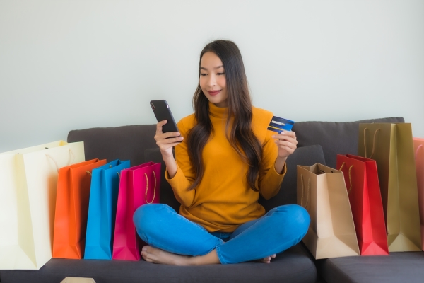 woman-using-laptop-computer-with-smart-mobile-phone-credit-card-online-shopping