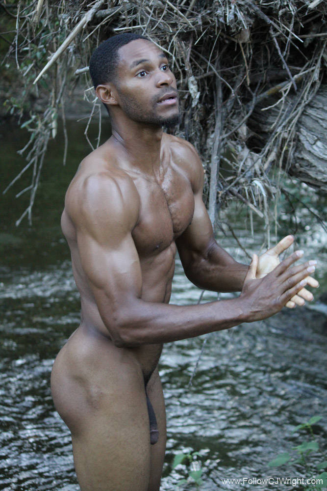 Gay male content creator CJ Wright posing naked outside near a small pond of water