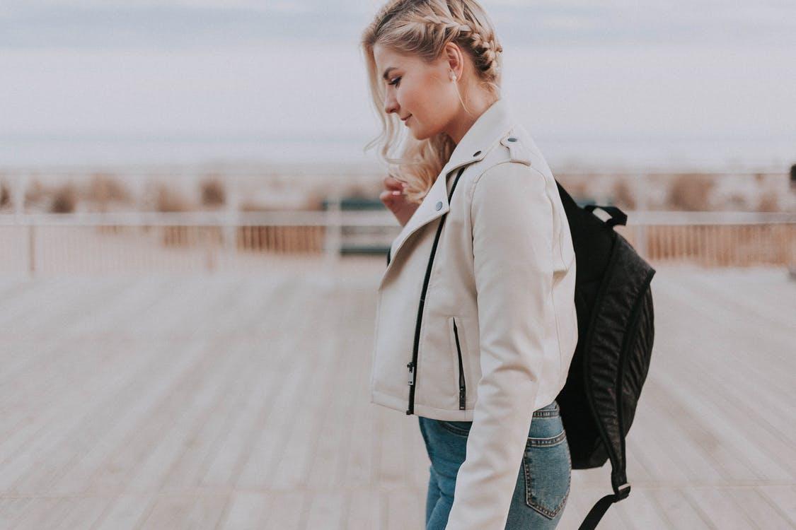 Woman in Black Zip-up Jacket With Black Backpack