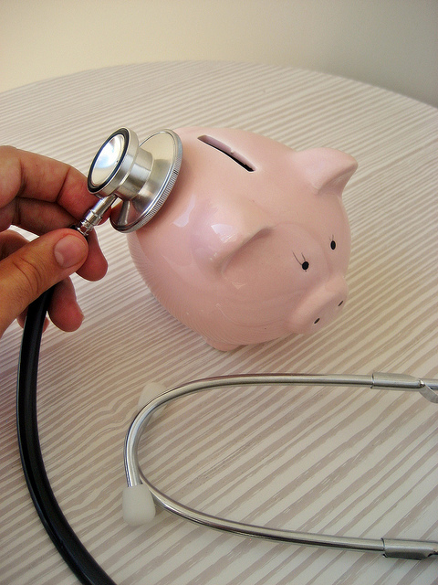 Using stethoscope on pink piggy bank