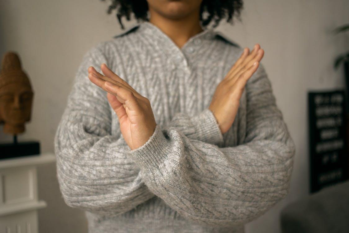 Free Calm black woman crossed arms as restriction sign in light room Stock Photo