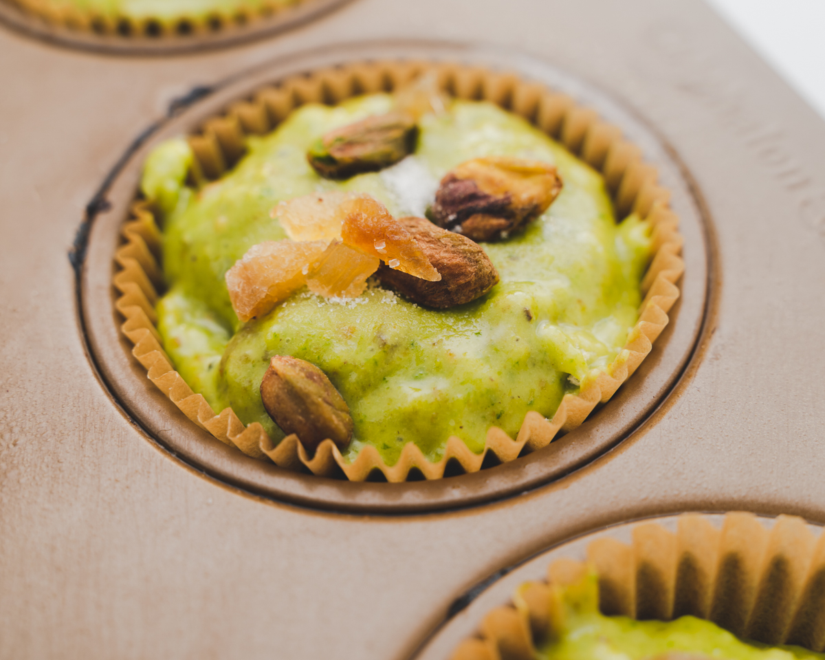 pistachio muffins batter topped with crystallized ginger and pistachios
