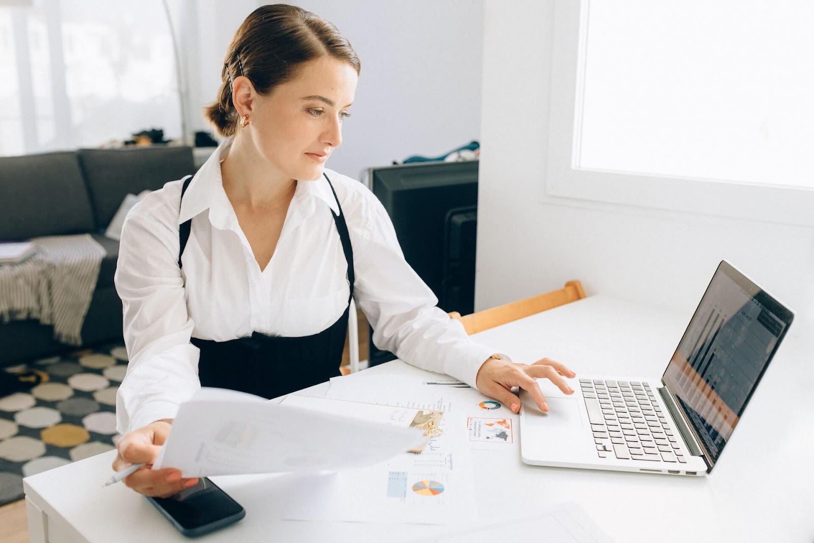 Woman going through financial papers at her computer