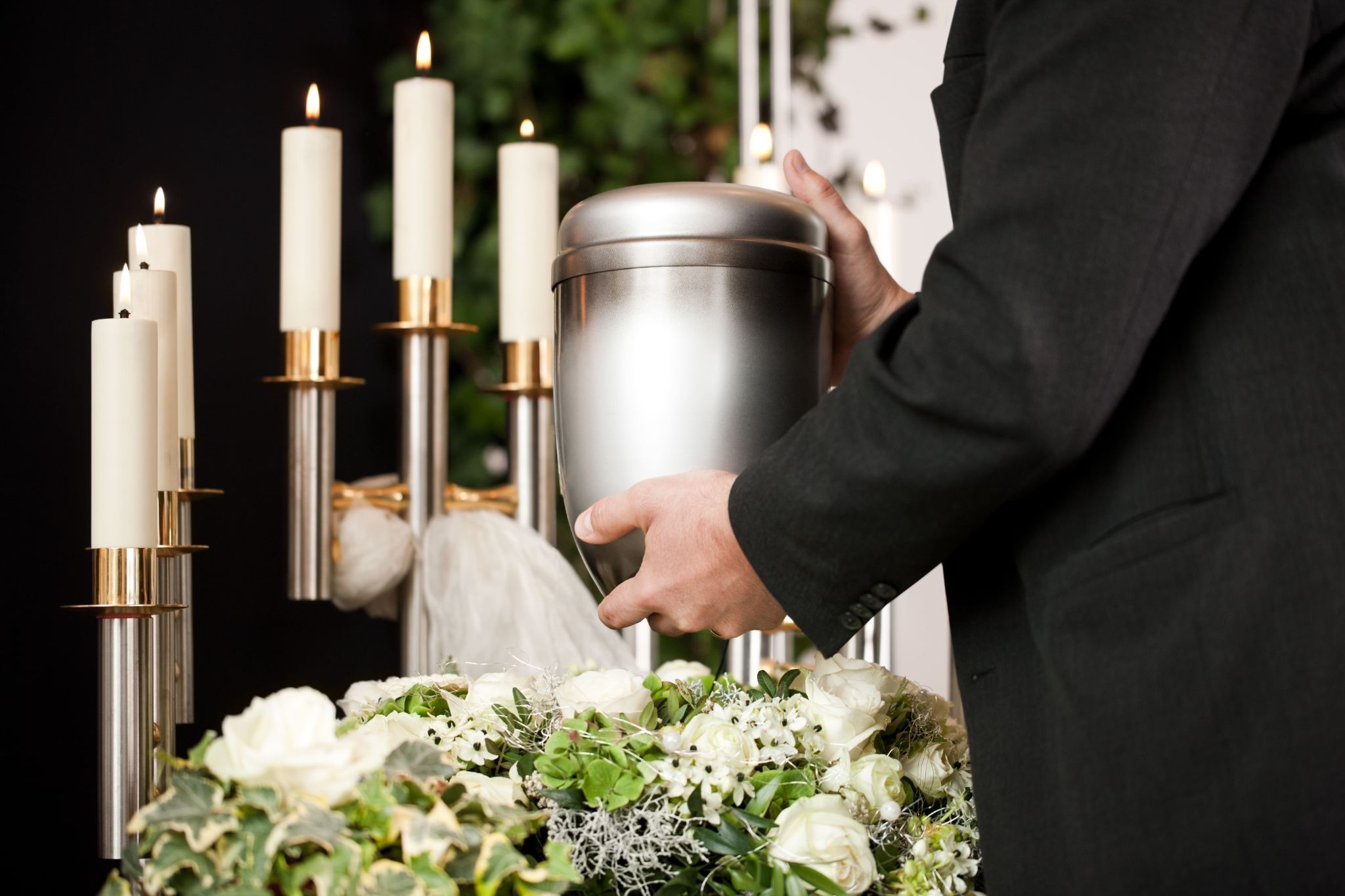 Cremar ou enterrar: homem segura urna funerária nas mãos.