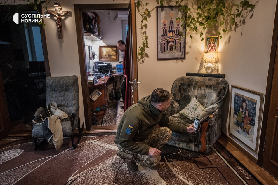 Сергій Дмитрієв фотографує картину з Різдвяним сюжетом вдома у секретаря Херсонської єпархії ПЦУ Івана Замараєва, Херсон, листопад 2022 року.