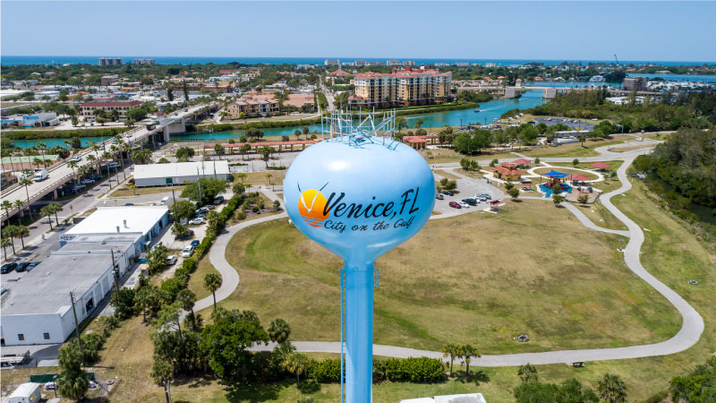 An aerial close-up shot of the Venice, Florida, water tower, with the city as the backdrop.