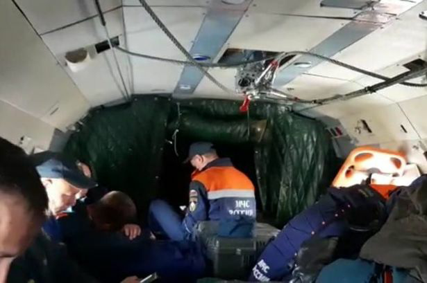 the Russian Ministry for Civil Defence, Emergencies and Elimination of Consequences of Natural Disasters (EMERCOM of Russia) shows a group of rescuers who are involved in the search of an An-26 plane, on board of a Mi-8 helicopter, in Kamchatka, Russia