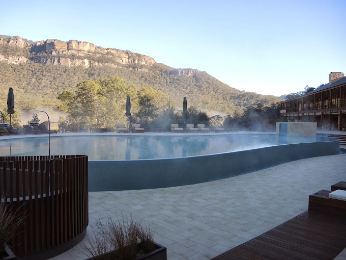 a pool with hot water and a mountain in the background