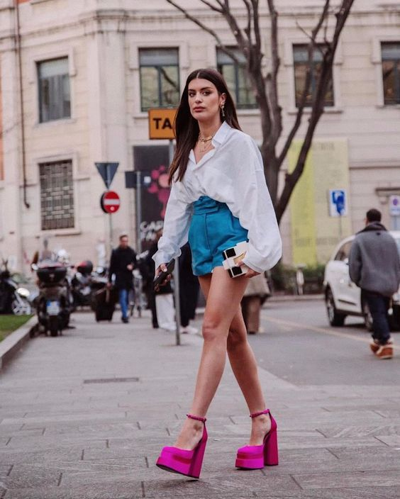 A lady wearing shorts and a white shirt with pink shoes for women