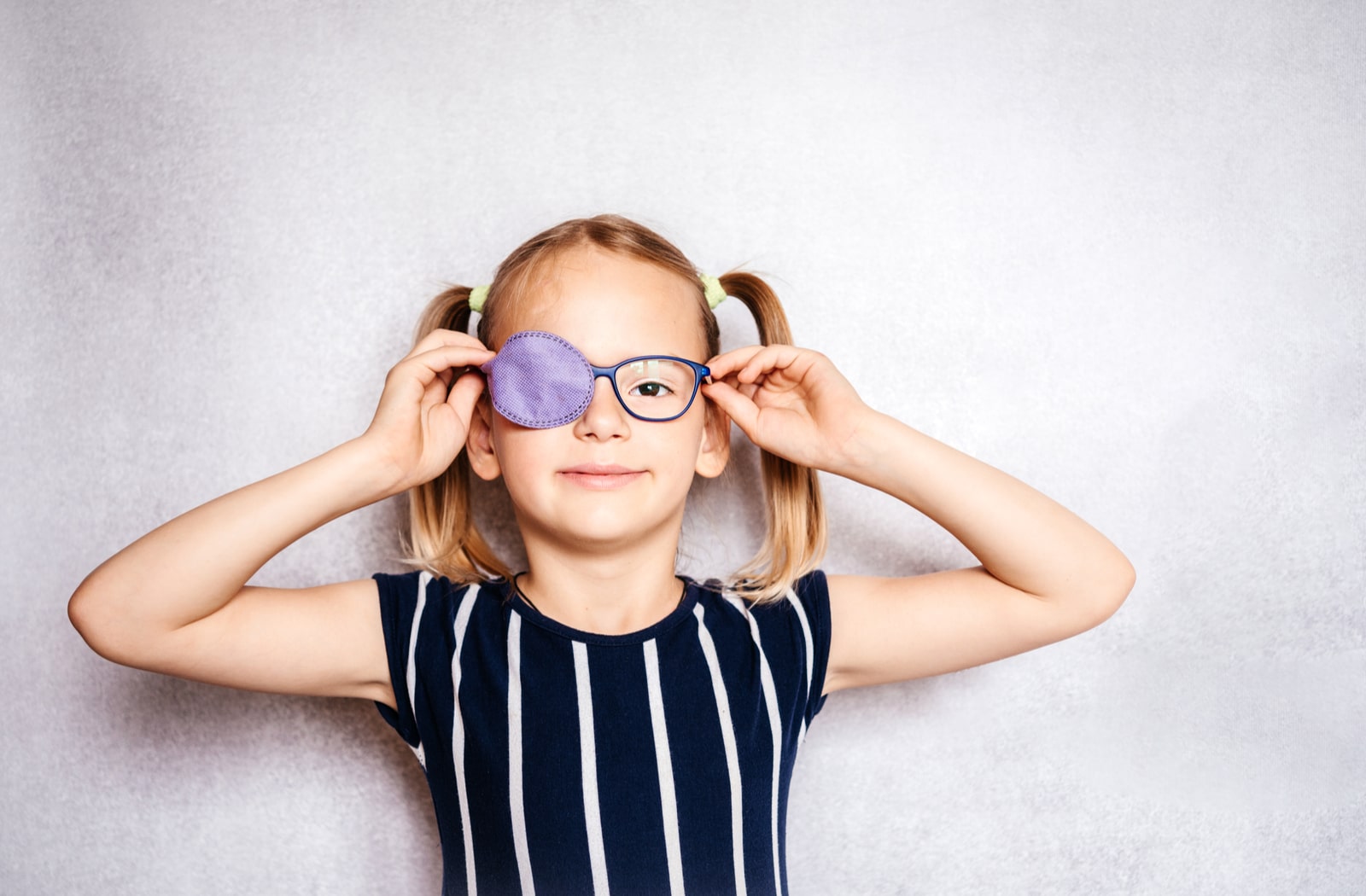 A young girl wearing an eye patch over her left lens to correct lazy eye