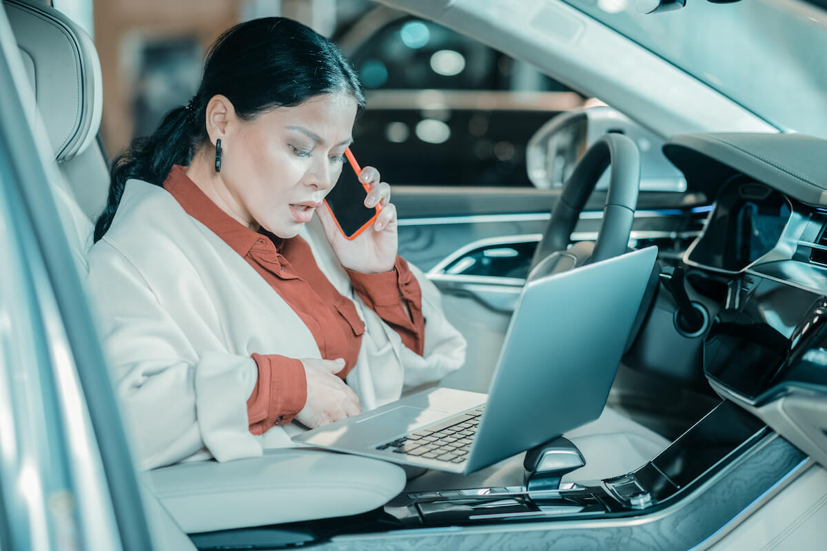 Mobile EHR software: woman talking on the phone while looking at a laptop