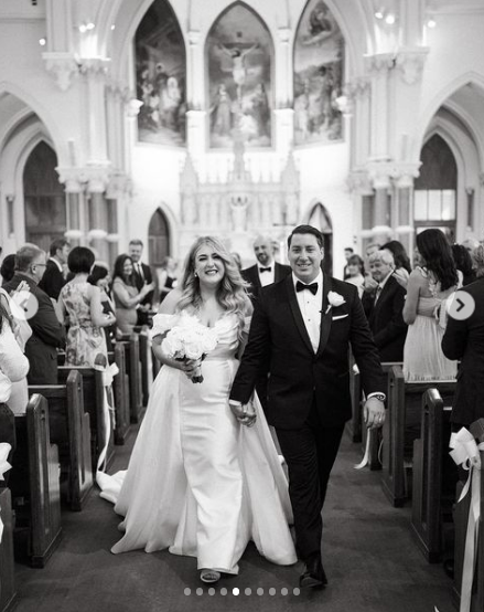 Couple smiling and holding hands as they exit their wedding ceremony