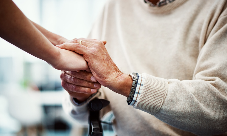 caregiver takes the hands of a senior living resident