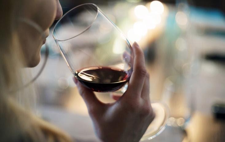 A person holding a glass of wine  Description automatically generated with medium confidence