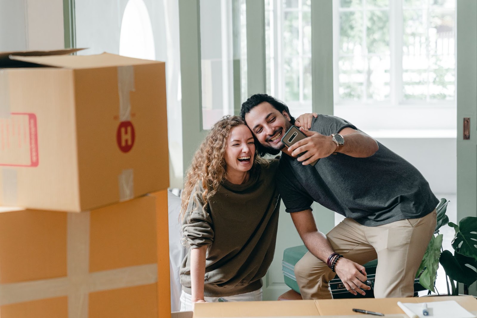 first time home buyers in bc pose for selfie with moving boxes