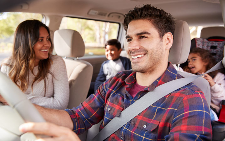 A happy family of four driving to their new home after successfully preparing for their move.