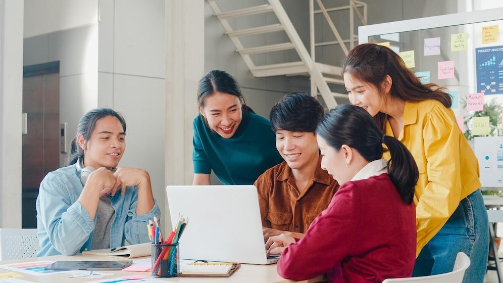 A group of people looking at a computer  Description automatically generated with medium confidence