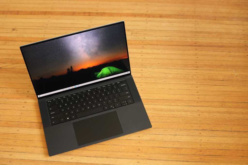 This image shows the Dell XPS 15 2022 on the brown table.