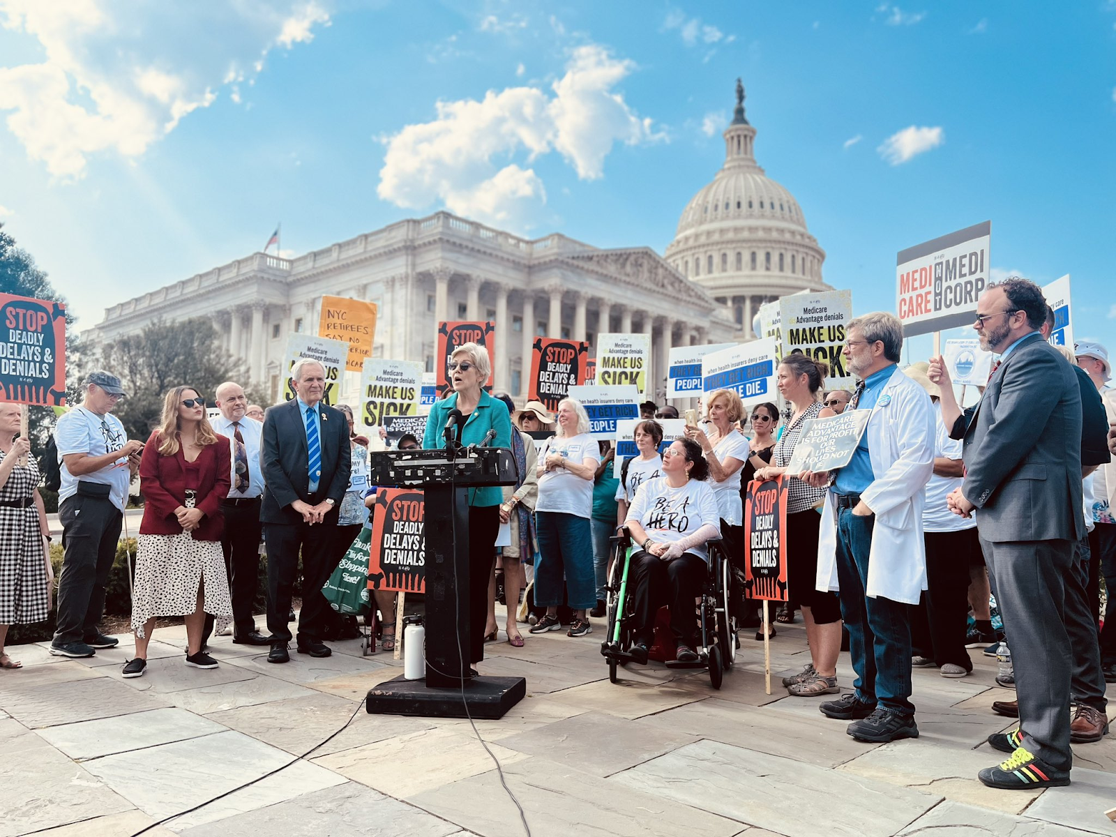 Senator Elizabeth Warren and a crowd of advoactes meet in front of the Capitol