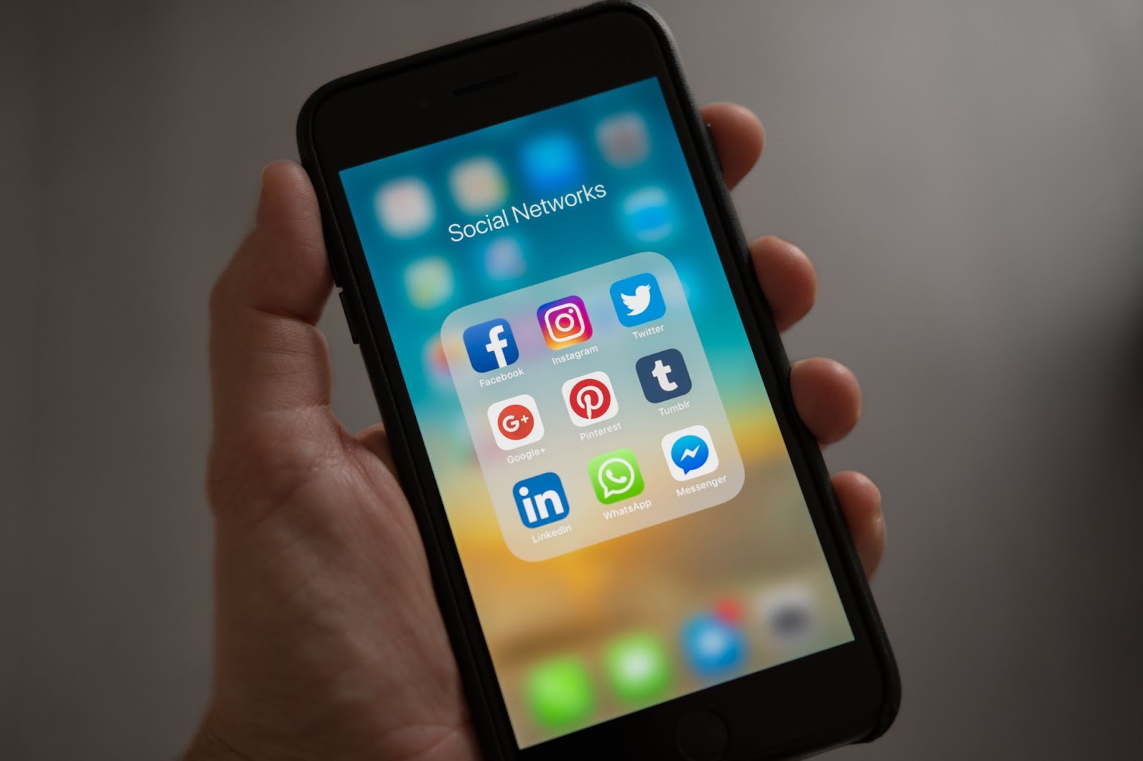 Phone showing social media networks icons; how to create a content strategy 