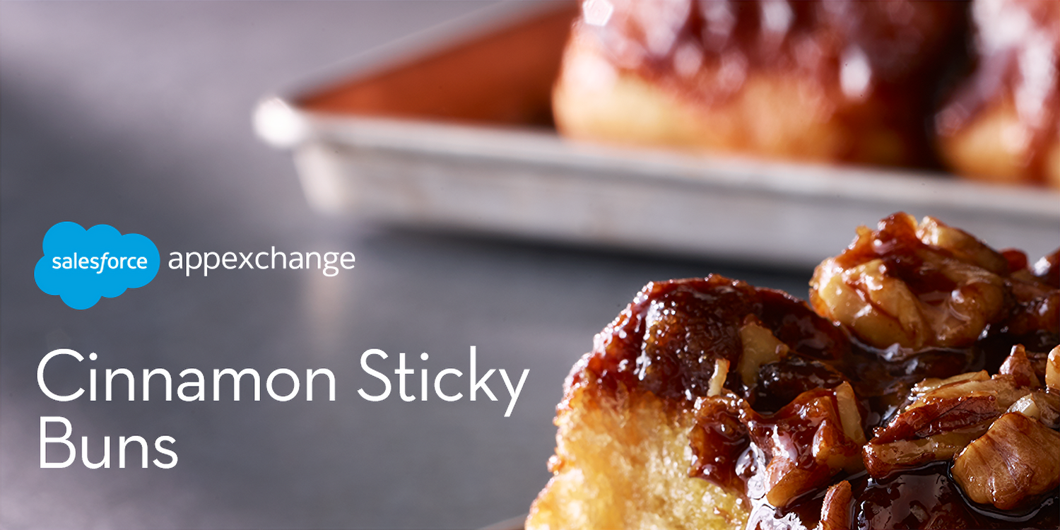 A photo of gooey cinnamon sticky buns, with a soft focus of a full tray of the Trailblazer treat in the background.