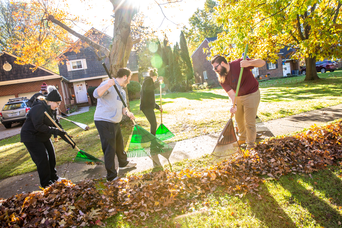 Students raking leaves in the fall.