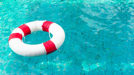 a red-and-white buoy floating in a sparkling swimming pool