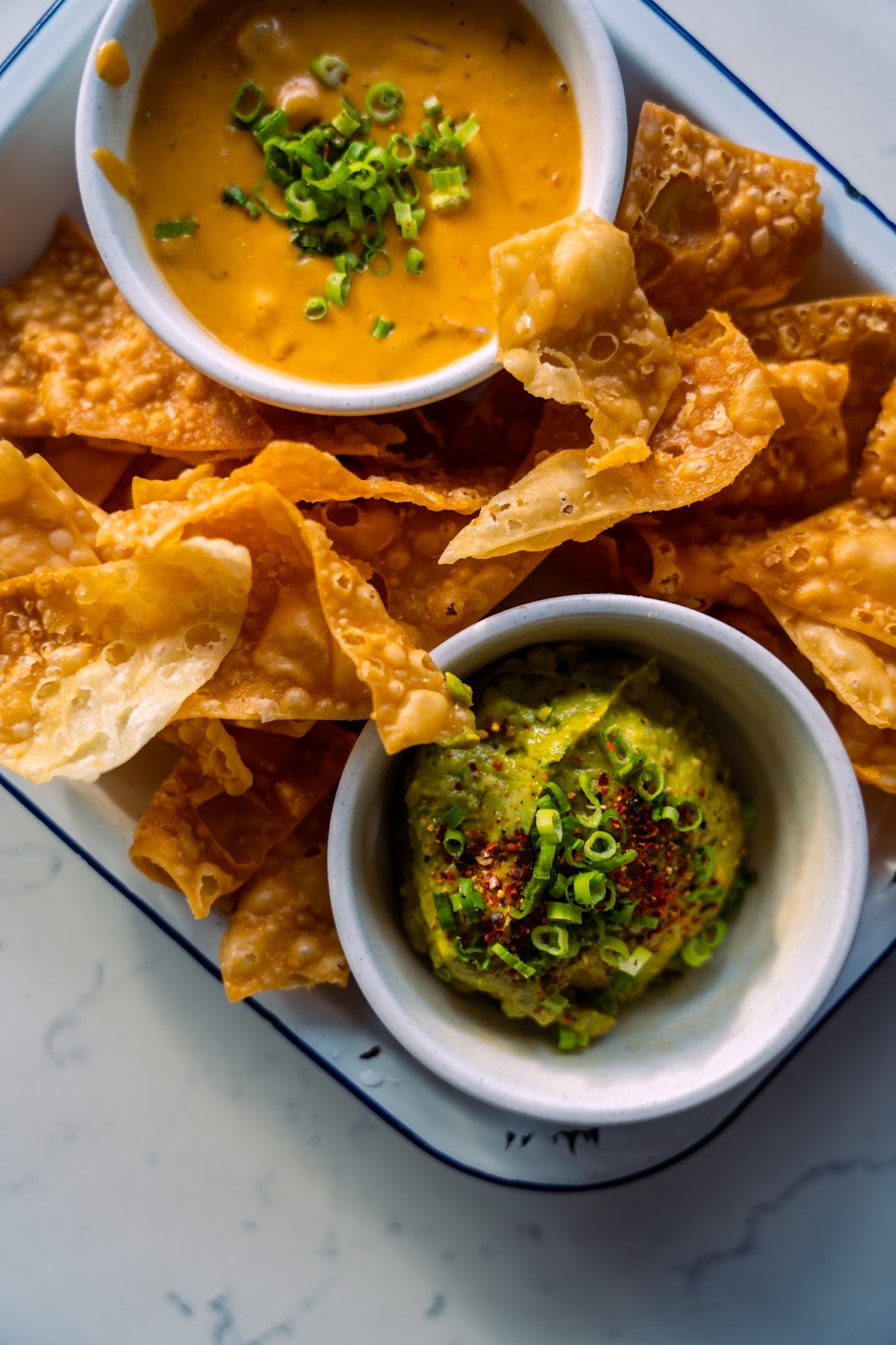 the restaurant style queso served with chips and guacamole