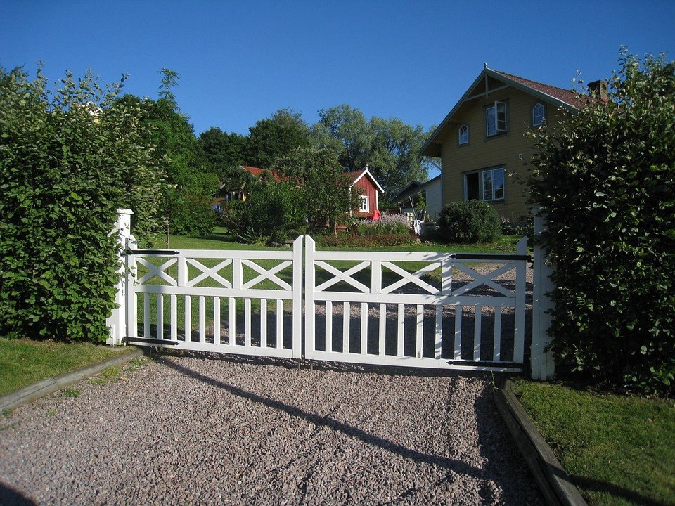Gravel driveway near white gate