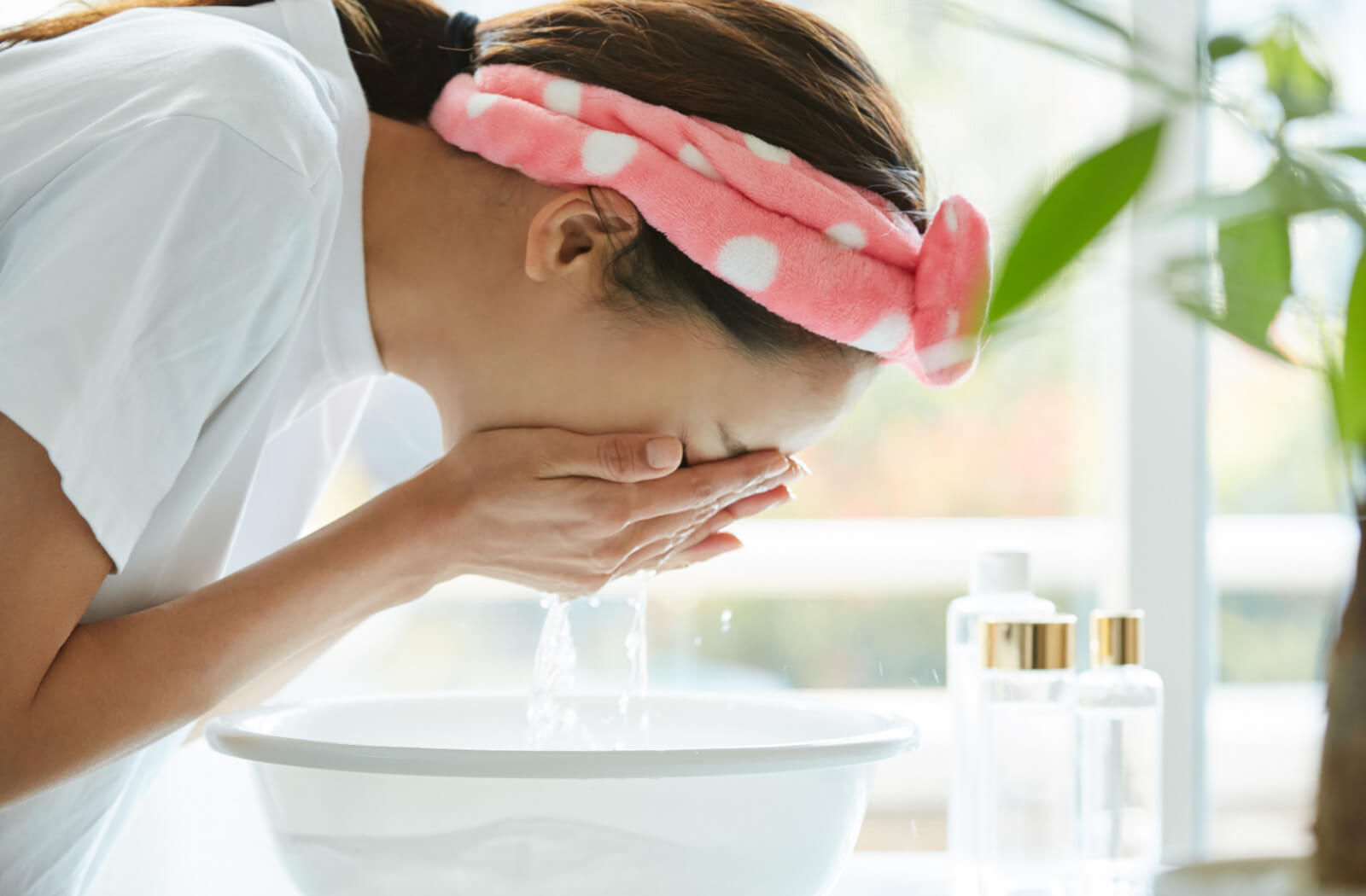 A young woman washed her eyes to clean her eyelids with water.