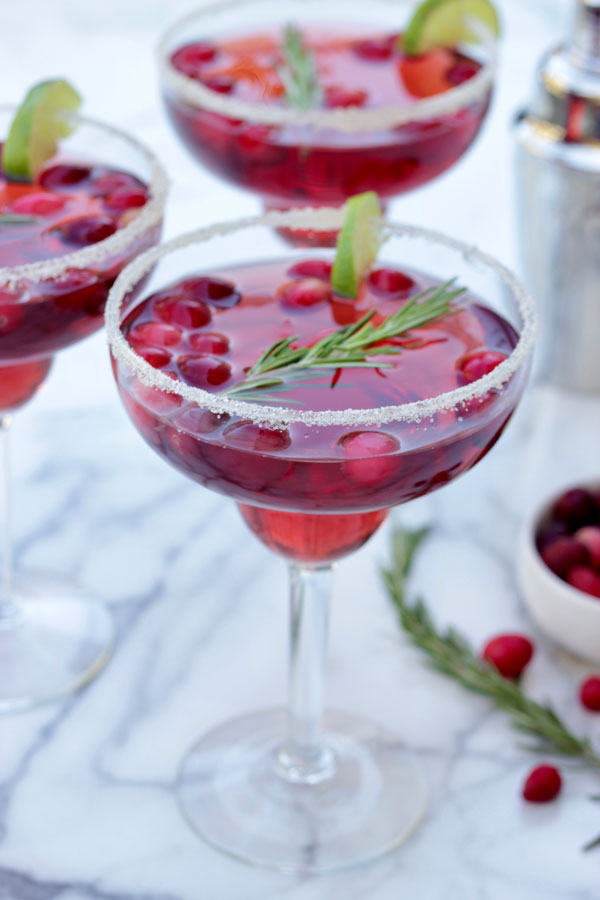 Cranberry margaritas with lime and rosemary garnish