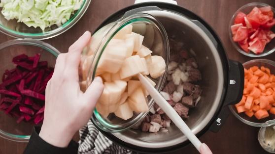 putting diced potatoes in a pressure cooker