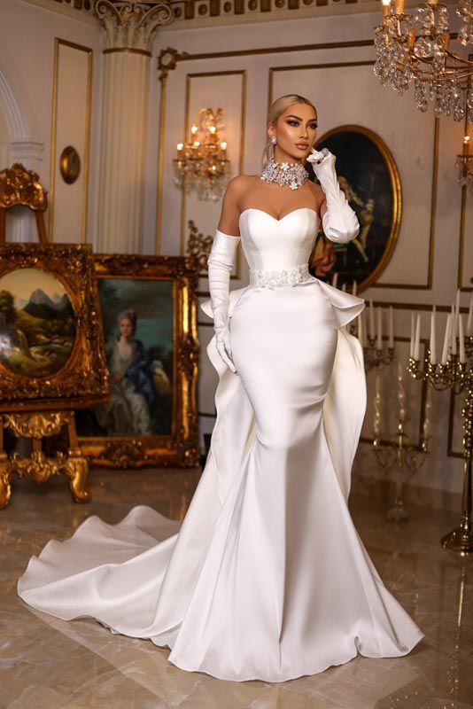 a lady wearing a strapless corset wedding gown with gloves and a statement neckpiece