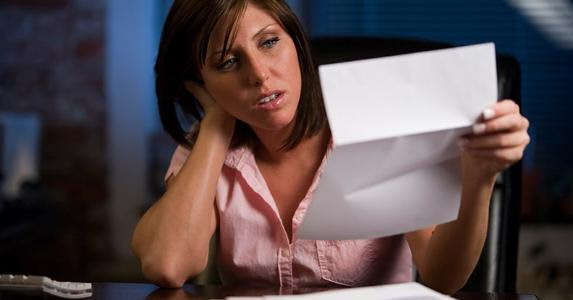 Confused woman reading paperwork © iStock