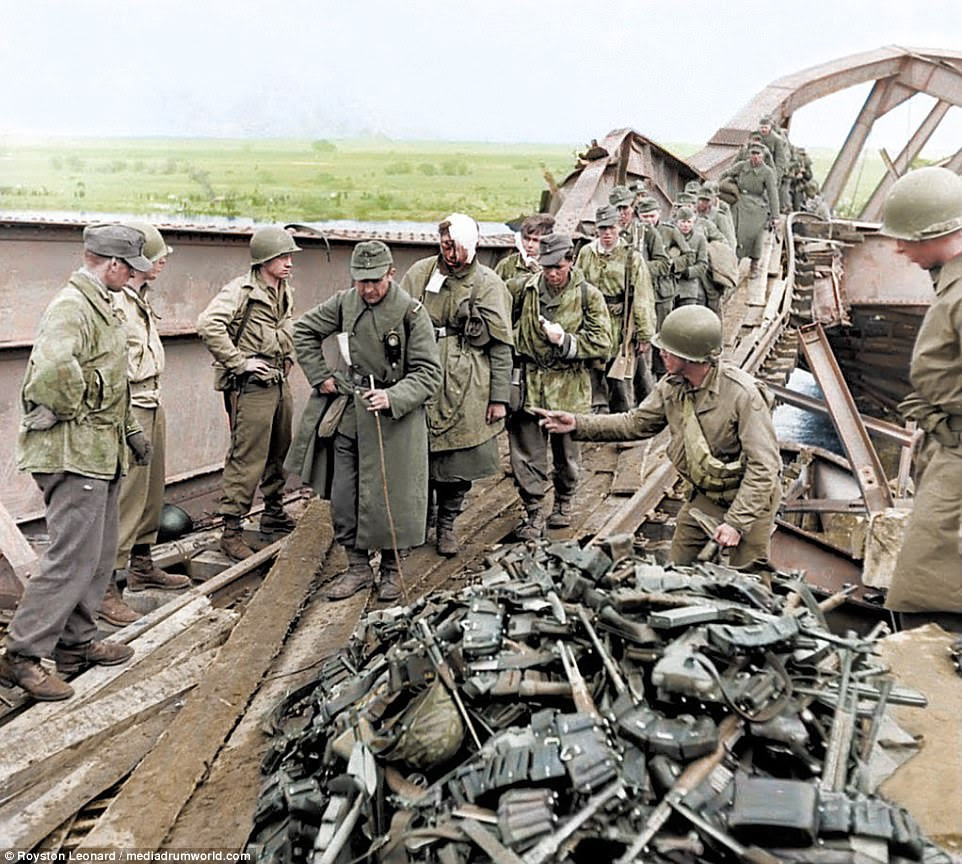 As the British and allied forces battered the Nazis into submission, the soldiers were left with no option but to hand over their weapons. A huge mountain of rifles and ammunition pile up as a conveyor belt of wounded Germans dump their guns