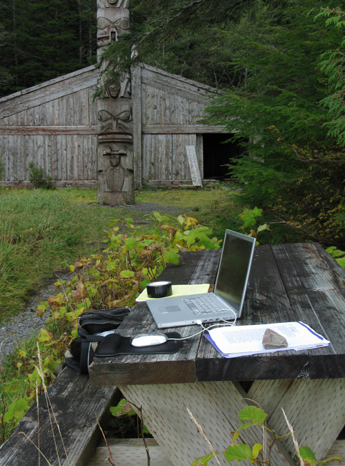 laptop on picnic table near Chief Son-i-Hat's Whale House, Kasaan, Alaska
