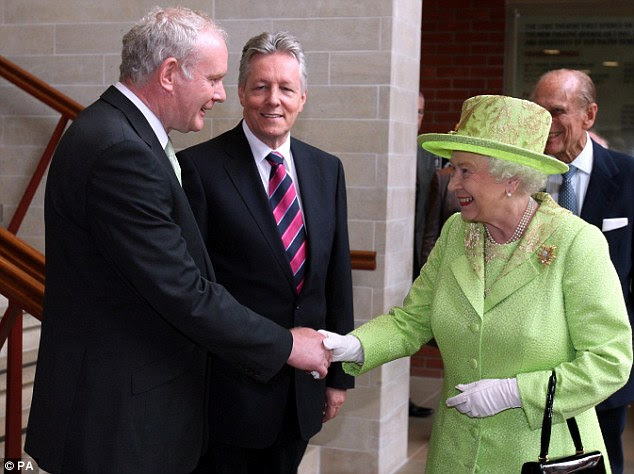 Historic moment: The Queen shakes hands with former IRA commander Martin McGuinness in front of Northern Ireland First Minister Peter Robinson (centre) and the world's cameras in Belfast today