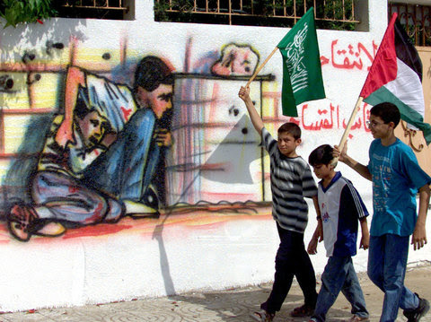 On Oct. 6, 2000, Palestinian boys in the Gaza strip walked past graffiti representing Muhammad al-Dura as he was shown in a television report.