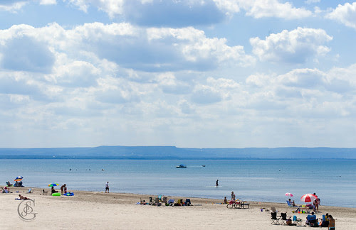 Wasaga Beach; a nearly empty beach stretches for miles with blue sky and water contrasting with the almost white sand