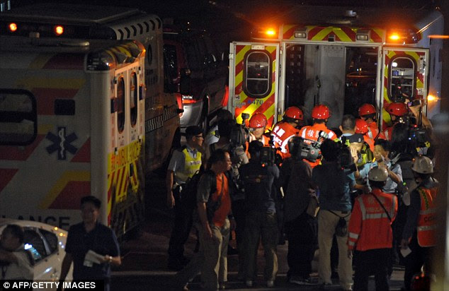 Interest: Members of the media surround rescue workers as they carry a victim into an ambulance
