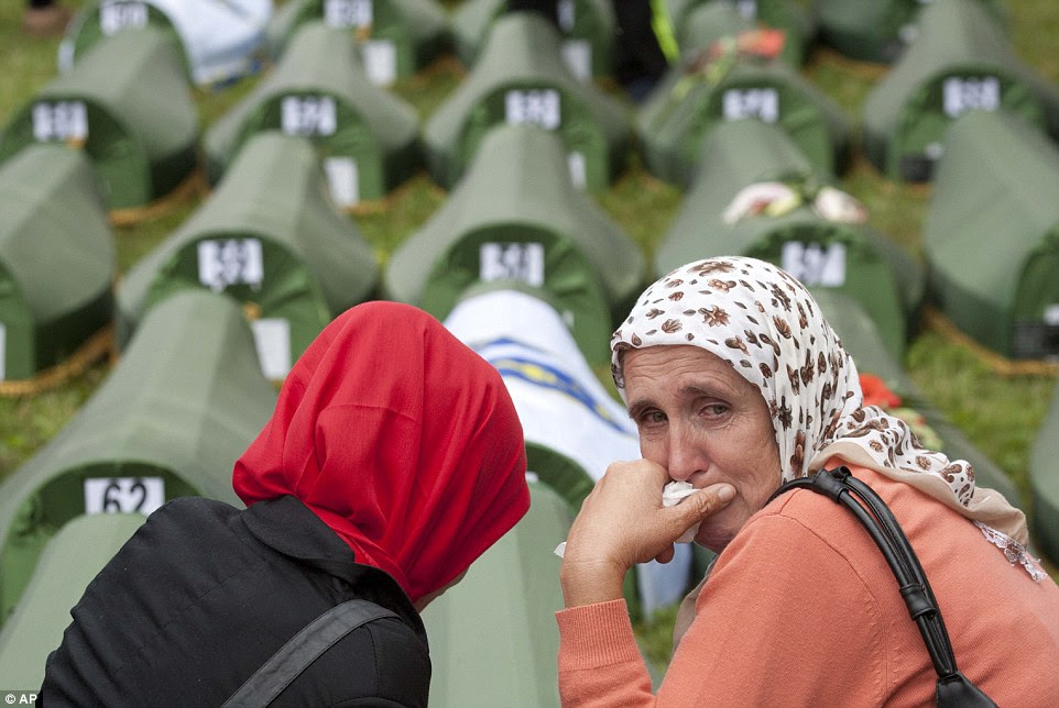 A Bosnian Muslim woman cries near coffins during a memorial ceremony and funeral in Srebrenica, Bosnia, Friday, July 11, 2014. Thousands of people gathered at the Potocari Memorial Center for a memorial ceremony and funeral of 175 victims of Europe's worst massacre since World War II. (AP Photo/Amel Emric)