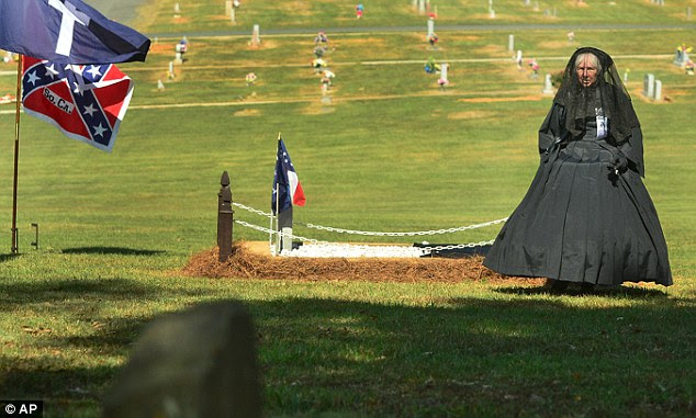 Funeral: Mattie Clyburn Rice, 91, was buried in Monroe, North Carolina today - in the same spot her Civil War veteran father was laid to rest. A Confederate 'Black Rose' mourner is seen by the grave