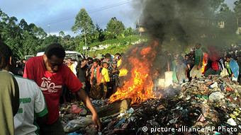 In this Wednesday, Feb. 6, 2013 photo, bystanders watch as a woman accused of witchcraft is burned alive in the Western Highlands provincial capital of Mount Hagen in Papua New Guinea. 