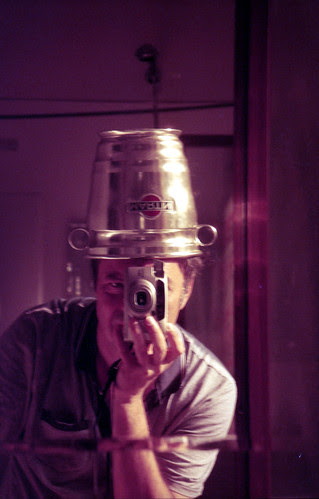 reflected self-portrait with Pentax Espio 160 camera and metal hat by pho-Tony