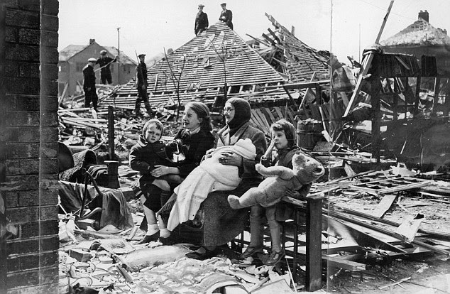 Ruined: In Liverpool, 68-year-old Sarah Manson sits outside her bombed home with her grandchildren after a Nazi bombing raid
