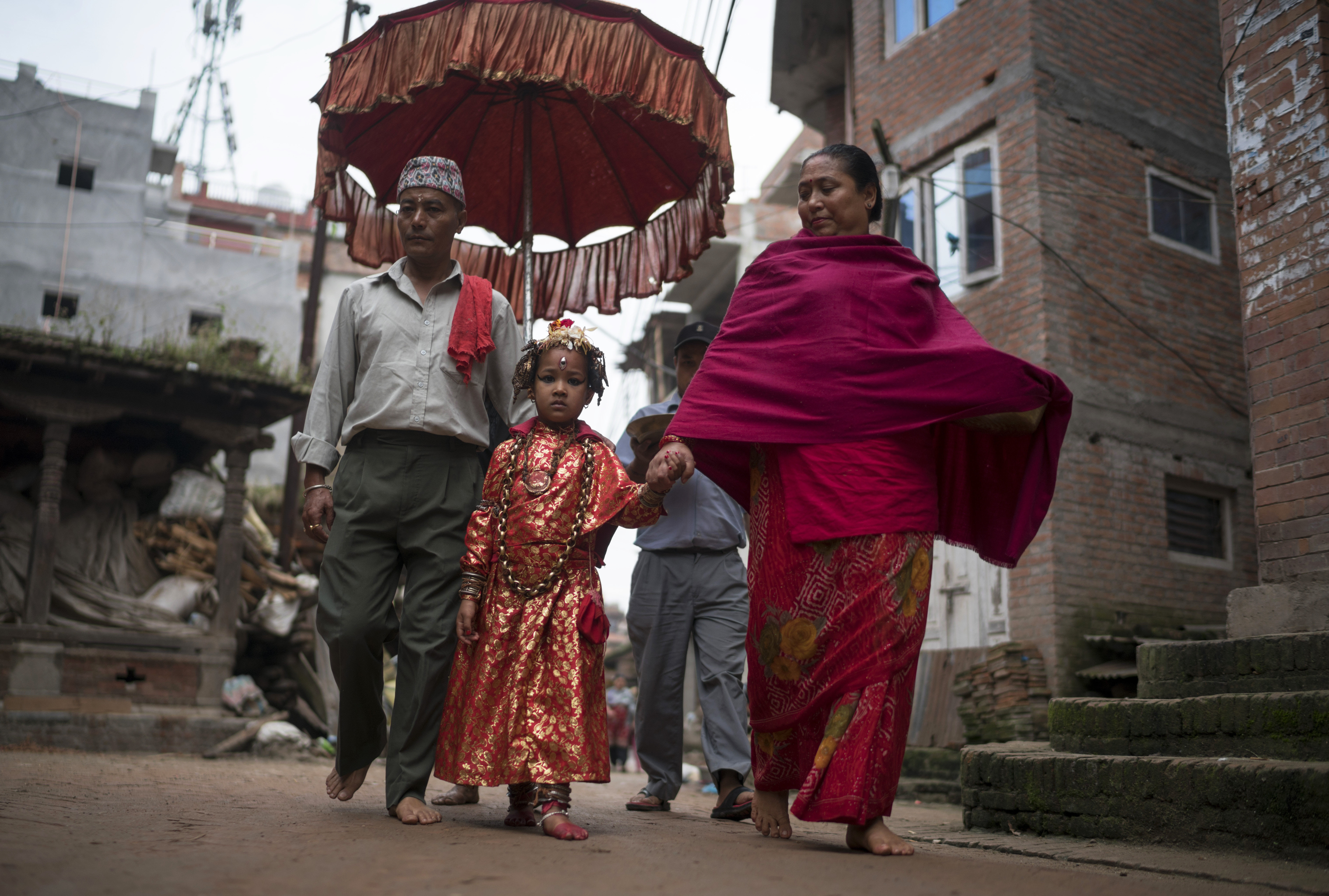 he Kumari priest and his wife escort Jibika Bajracharya, the newly appointed child goddess Kumari, through the streets on October 7, 2016 in Bhaktapur, Nepal. The Bhaktapur Kumari is a living child goddess and is an ancient tradition in Kathmandu Valley as devotees worship the newly appointed child goddess in order to receive blessings from ancestors or deities. As the new Kumari of Bhaktapur, Jibika Bajracharya performs her role in public during the 15-day long Dashain festival while spending the rest of the year as a goddess living a normal life with her parents at home until she is replaced at 11 years old. (Photo by Tom Van Cakenberghe/Getty Images)