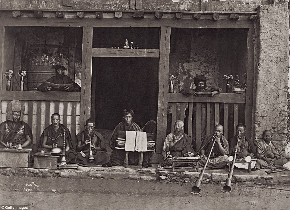 A troupe of Buddhist musicians outside a temple in Darjeeling, West Bengal, circa 1875. Photographer Robert Phillips signed off on this photo by scratching his name into the glass plate. 